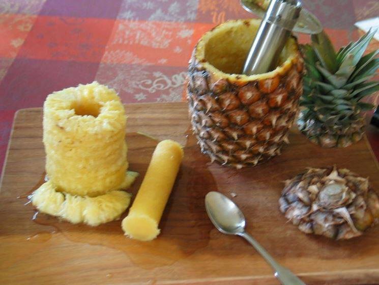 Ananas svuotato con il gambo centrale estratto, appoggiato su un tagliere